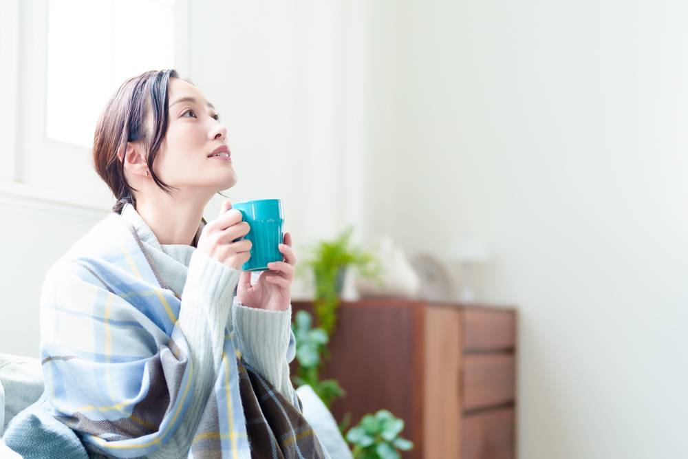 リビングでドリンクを飲む女性