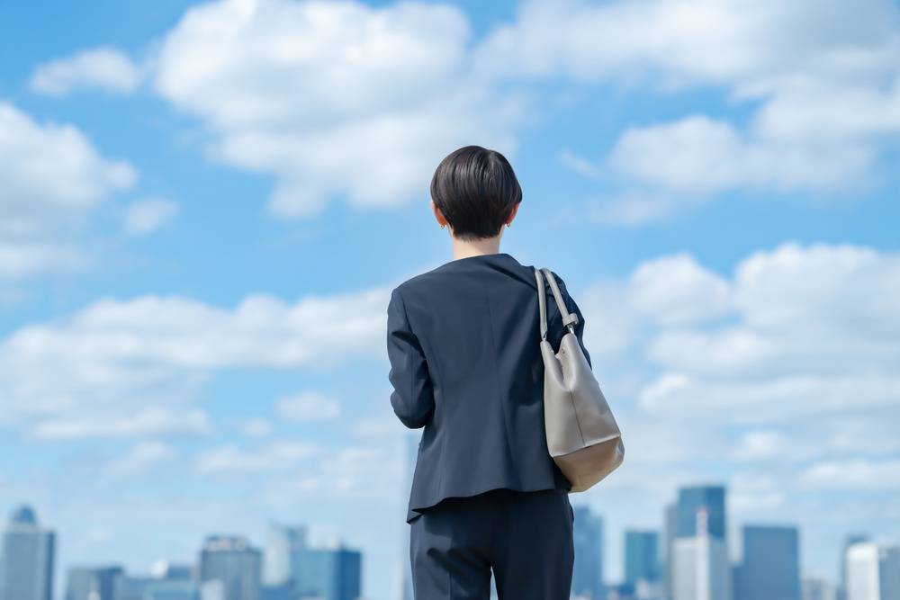 スーツを着た女性、青空