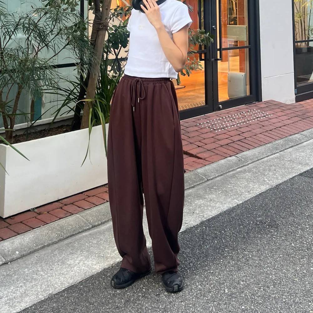 白トップスにブラウンパンツを合わせた女性