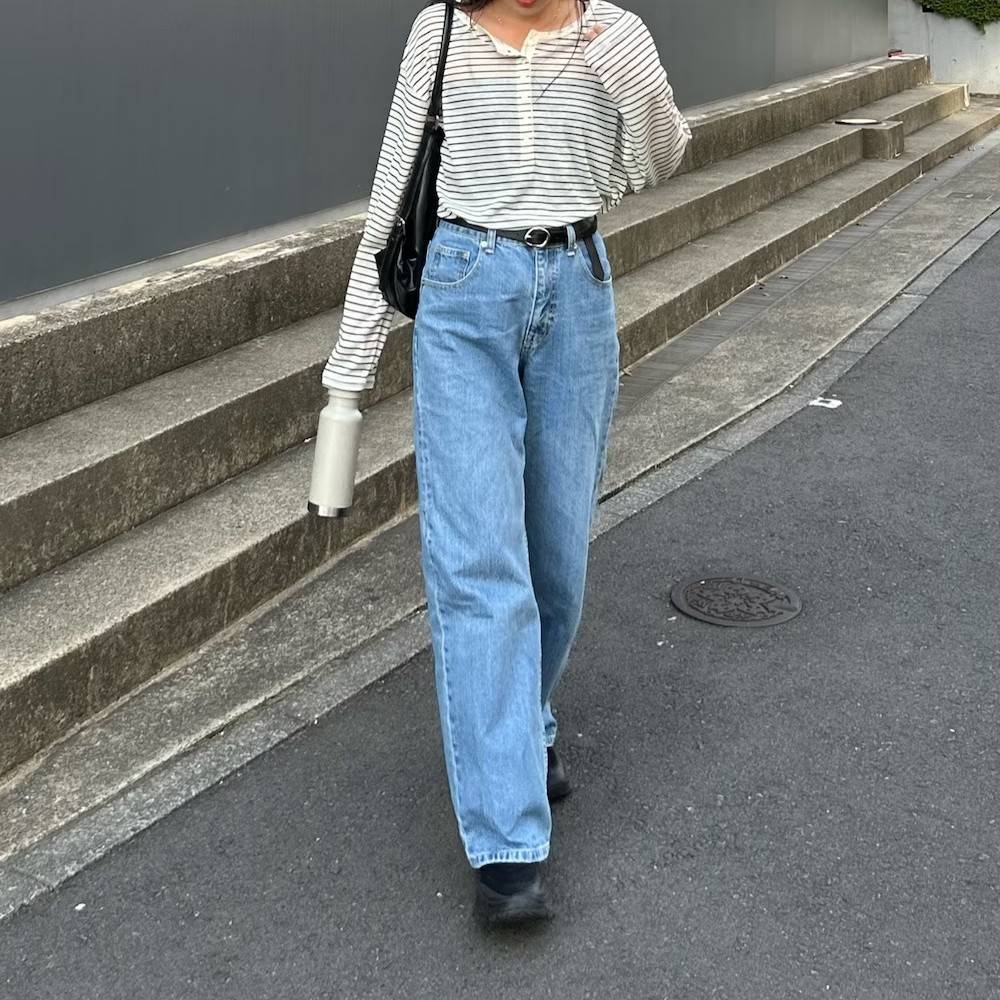 ボーダー柄のトップスにデニムパンツを合わせた女性