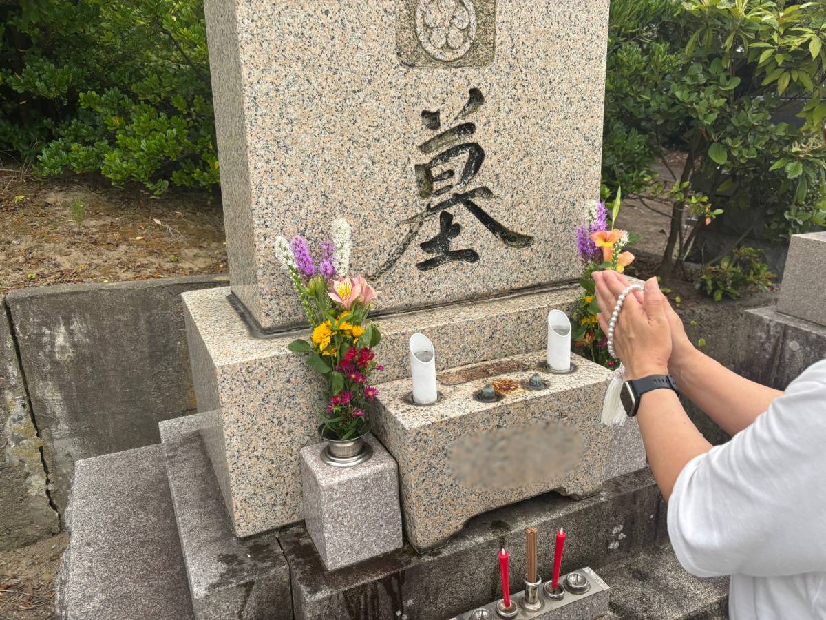 お墓に手を合わせる女性