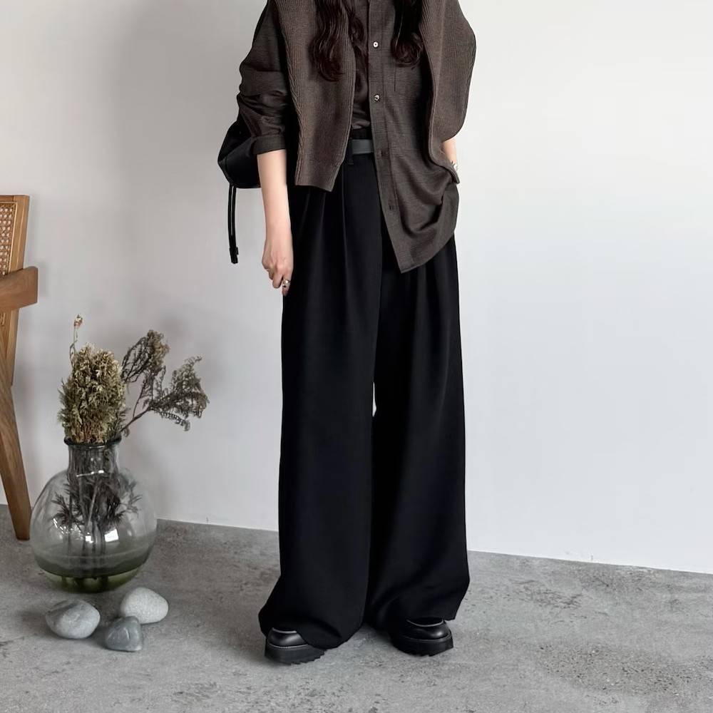 ブラウンのシャツに黒パンツを合わせた女性