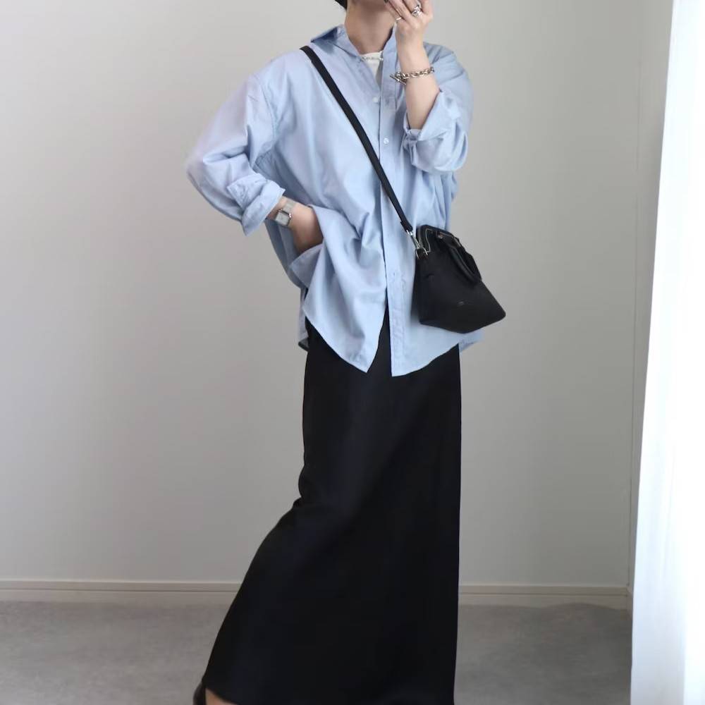 ブルーのシャツに黒スカートを合わせた女性