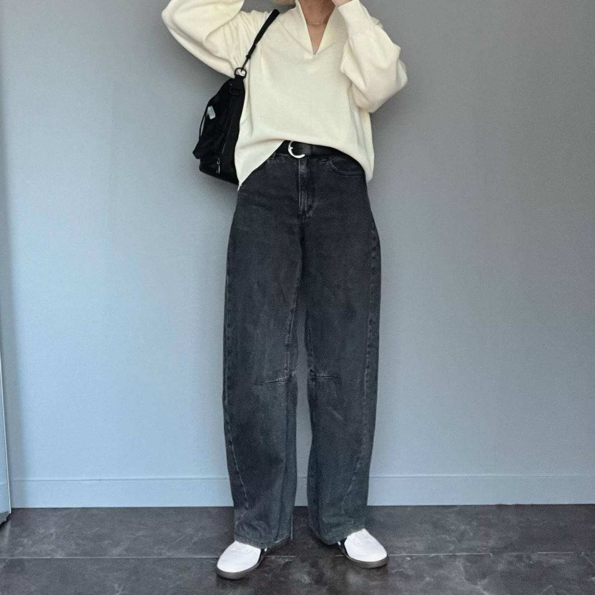 白トップスにデニムパンツを合わせた女性