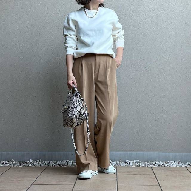 白トップスにベージュのパンツを合わせた女性
