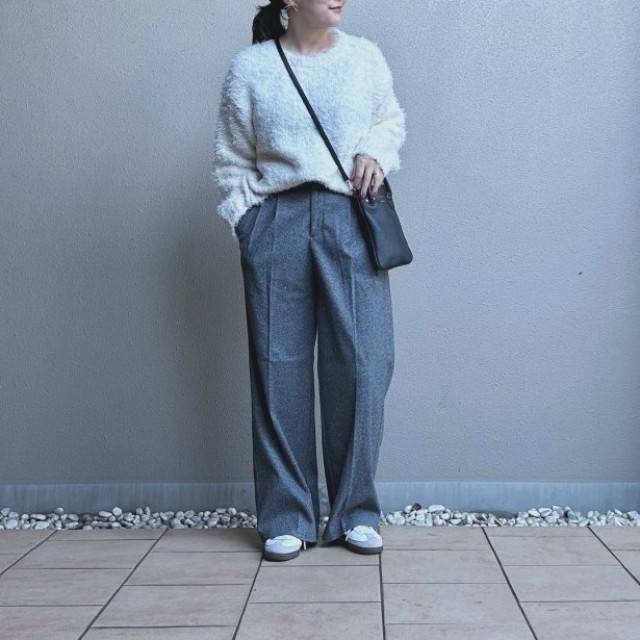 白トップスにグレーパンツを合わせた女性