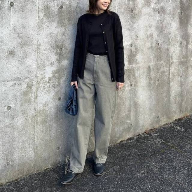 黒トップスにデニムパンツを合わせた女性