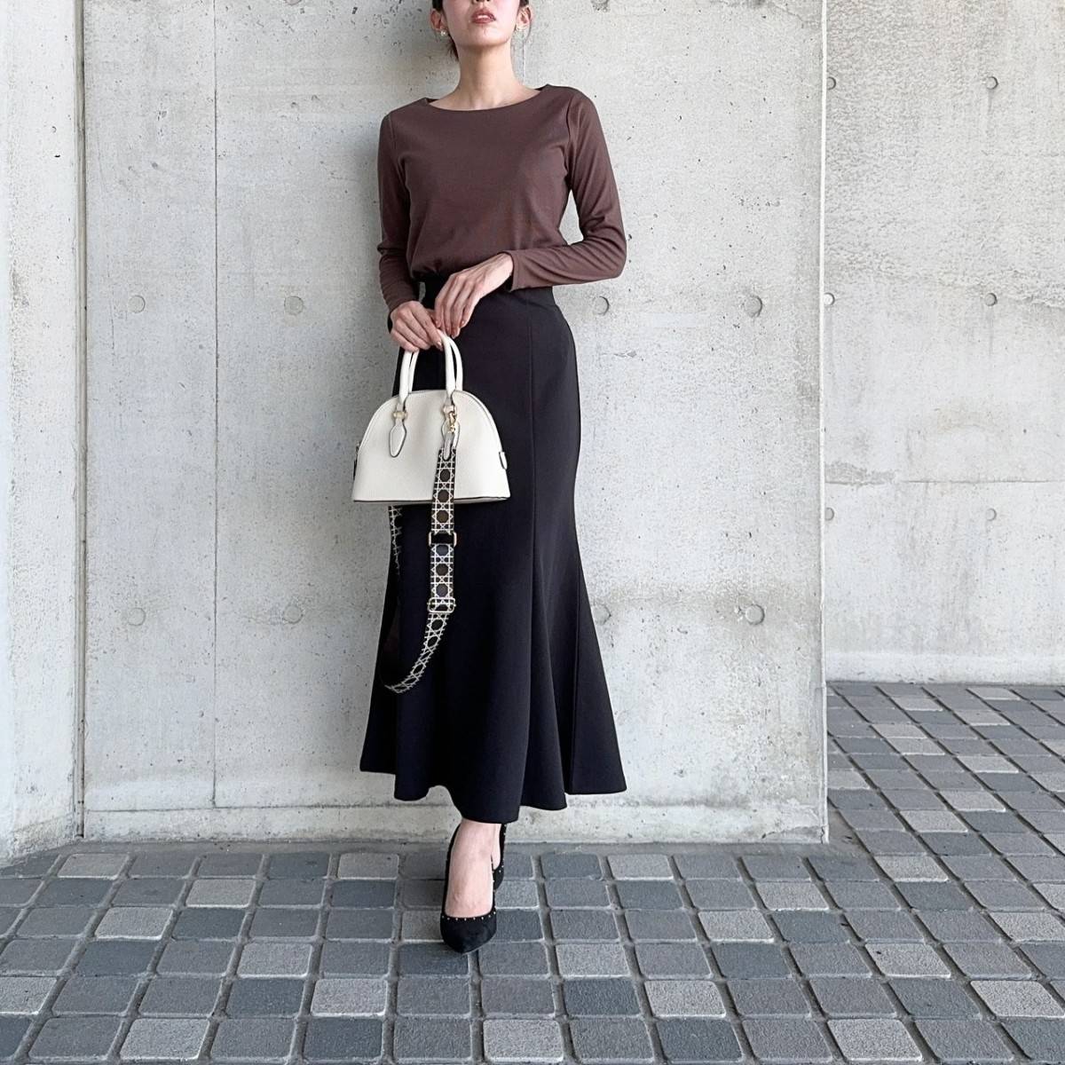 ブラントップスに黒スカートを合わせた女性