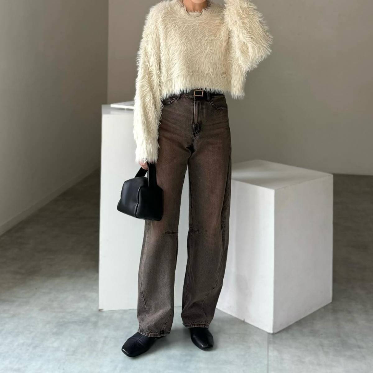 白ニットにデニムパンツを合わせた女性