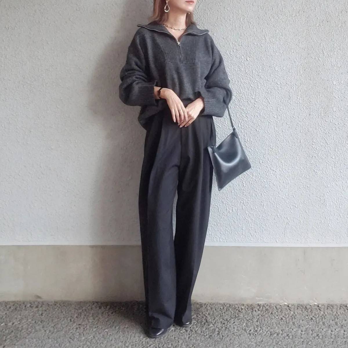 グレーのニットに黒パンツを合わせた女性