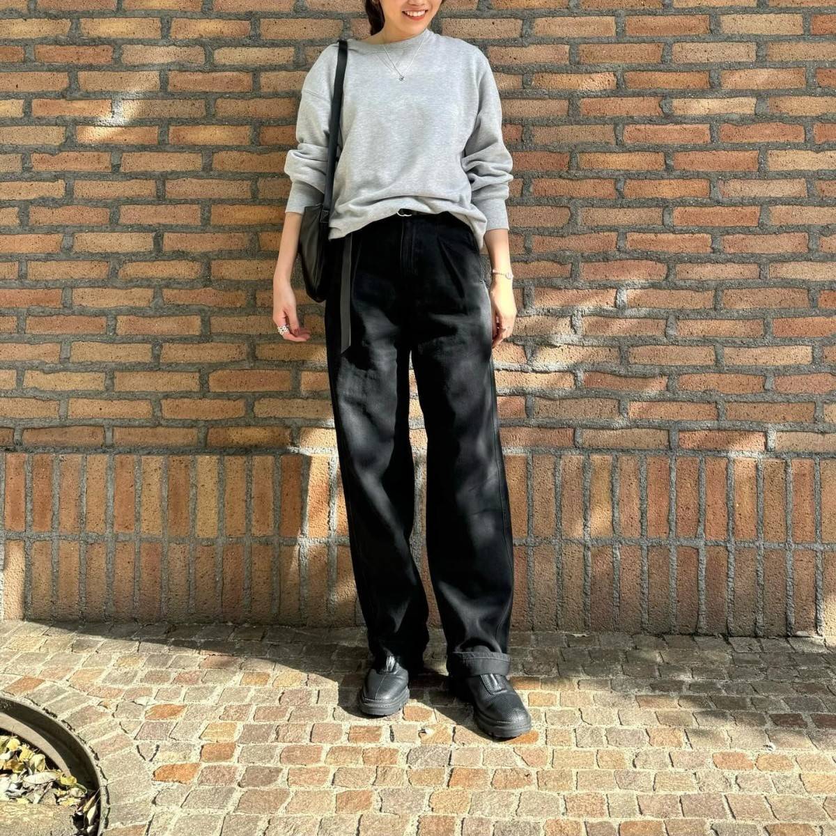 グレーのスウェットに黒パンツを合わせた女性
