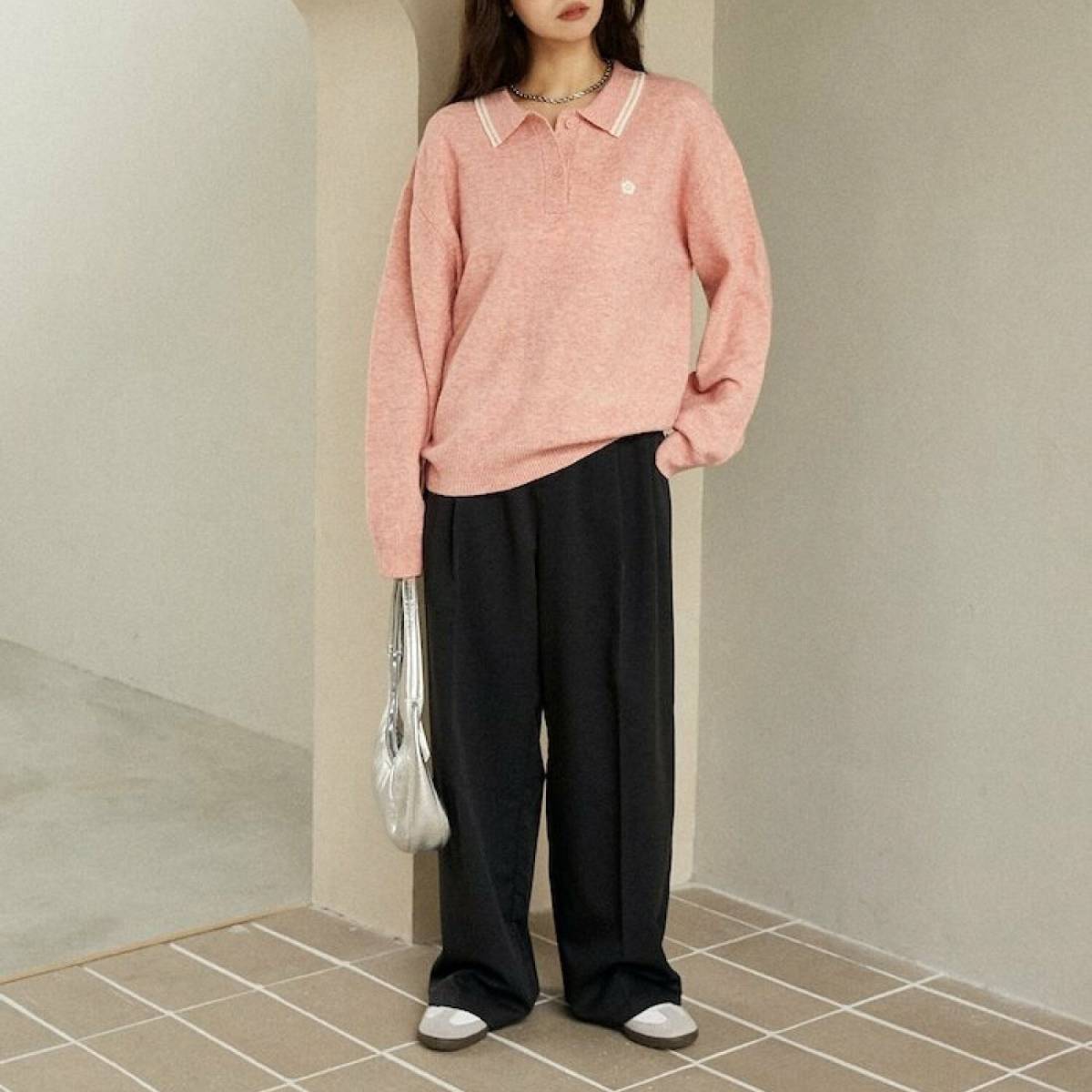 ピンクのポロシャツに黒パンツを合わせたコーデ