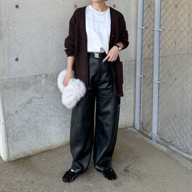 ブラウンカーディガンに黒スカートを合わせた女性