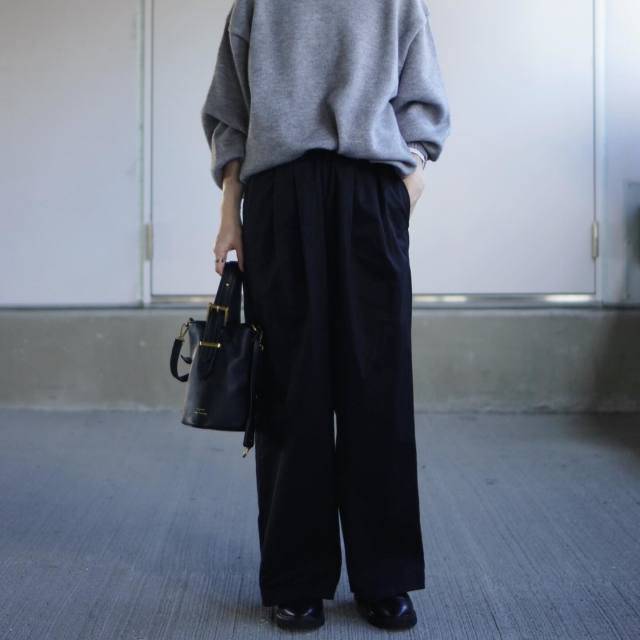 グレーニットに黒パンツを合わせた女性