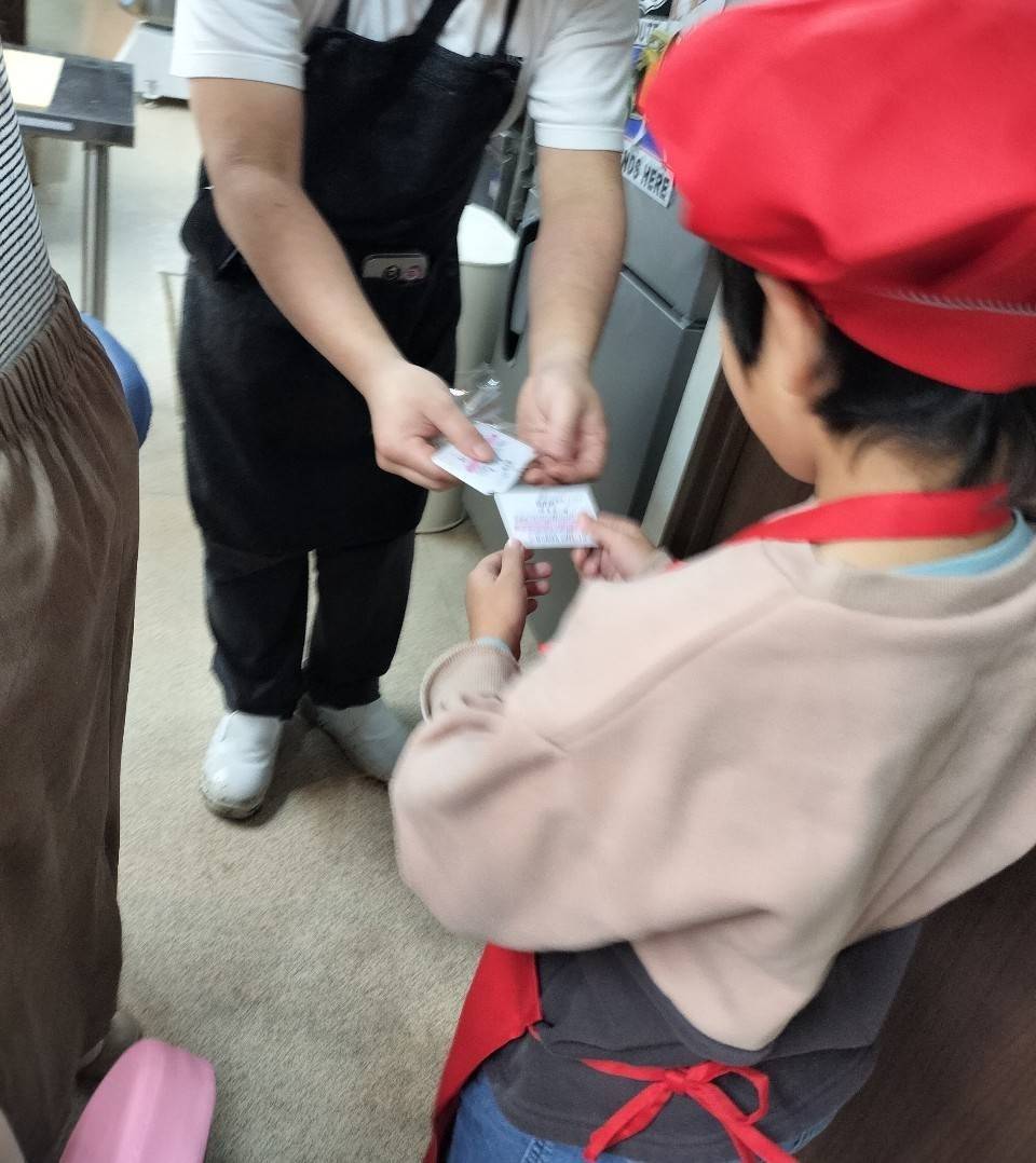 SIUNAUS SWEETSで券を受け取る男の子