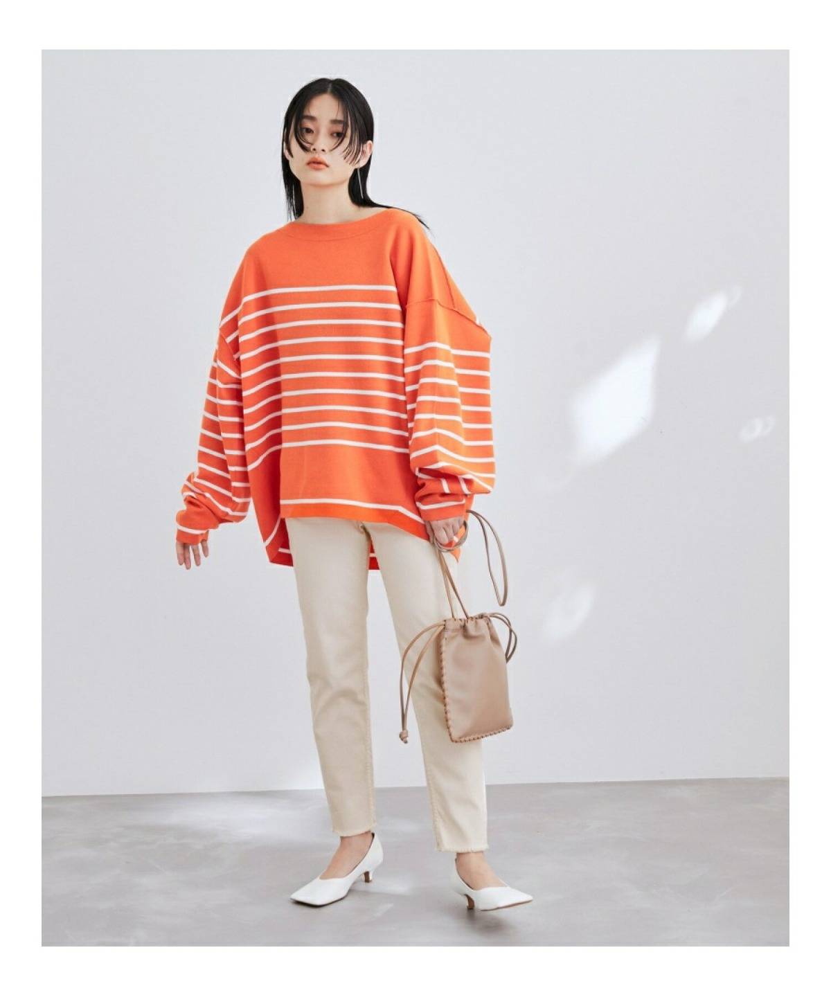 オレンジニットの秋冬コーデ 白パンツ