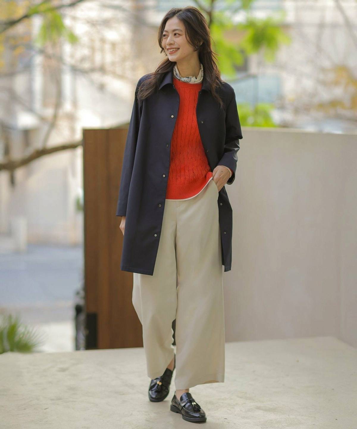 オレンジニットの秋冬コーデ ネイビーコート ベージュパンツ