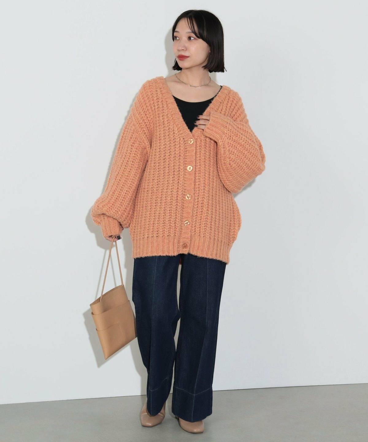 オレンジニットの秋冬コーデ オレンジニットカーデ×黒パンツ