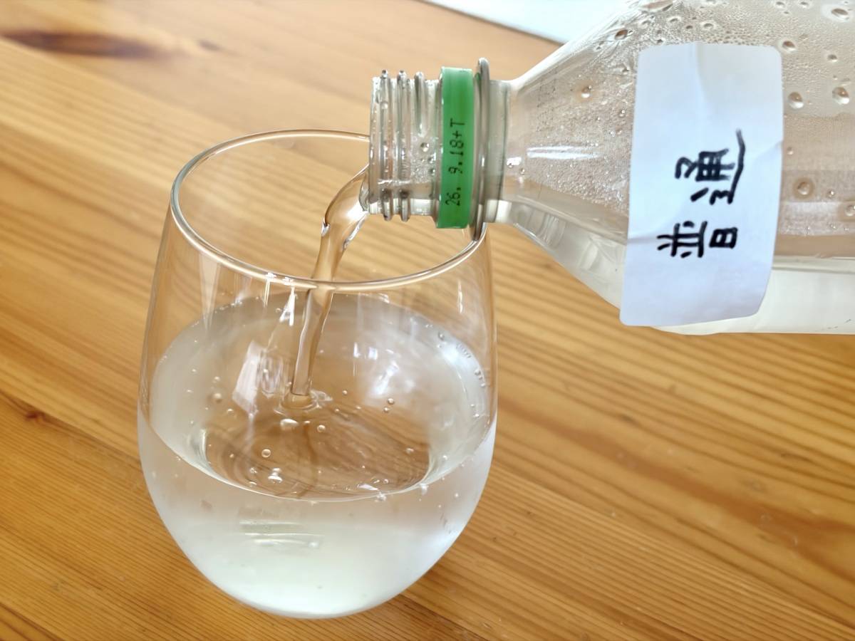 普通に立てた炭酸ペットボトルをグラスに注いでいるところ