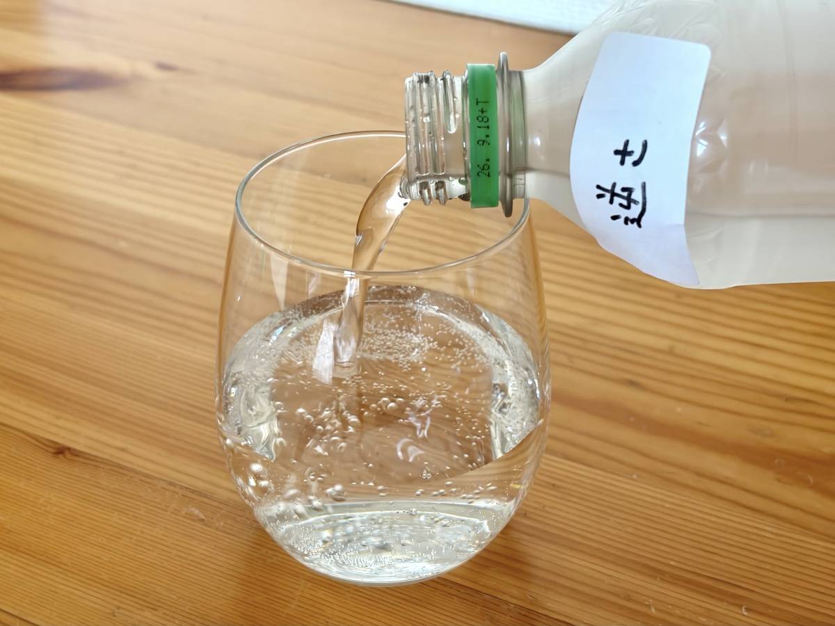 逆さまに保管した炭酸ペットボトルをグラスに注いでいるところ