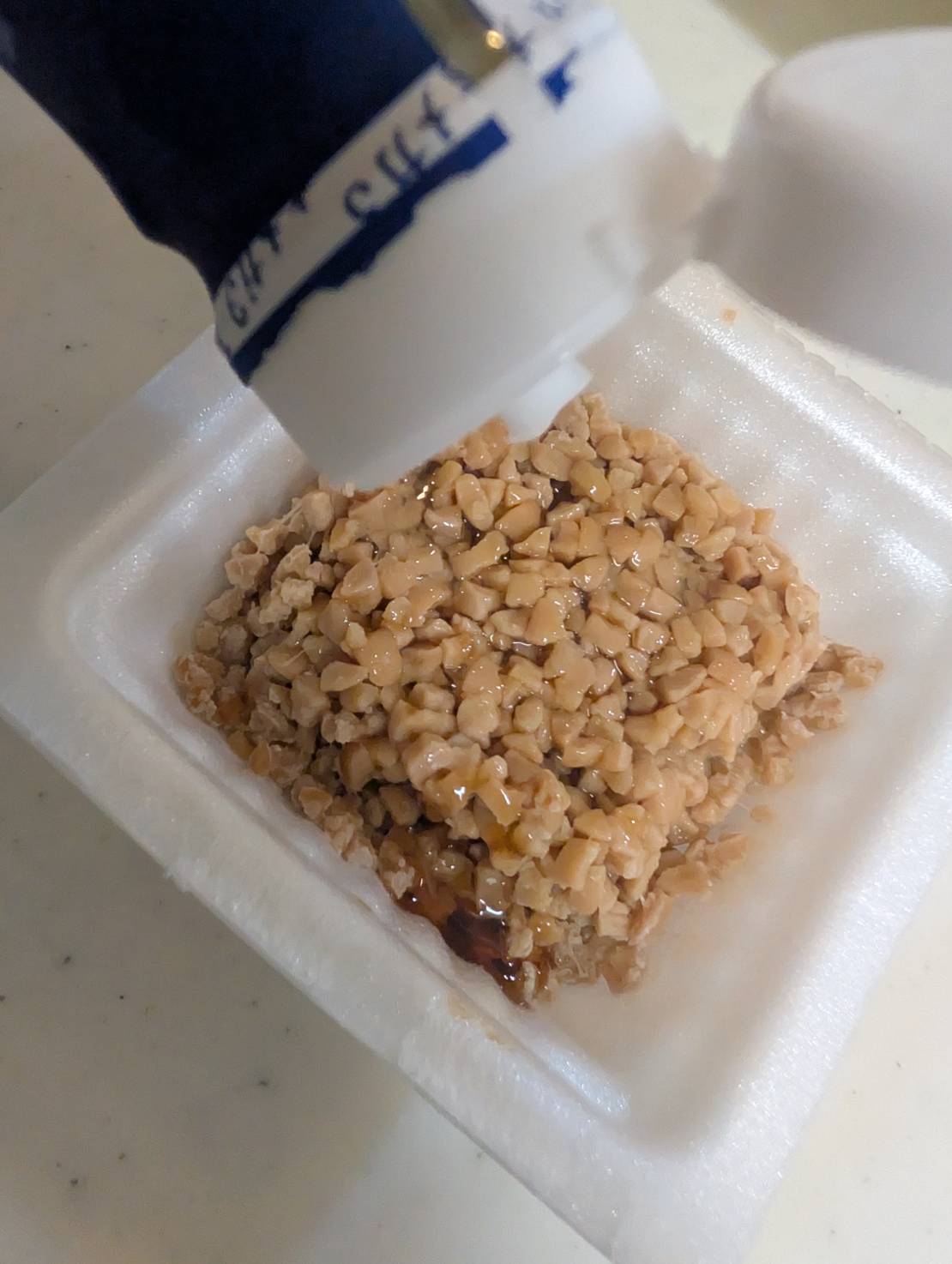 日清アマニ油を納豆にかけているところ