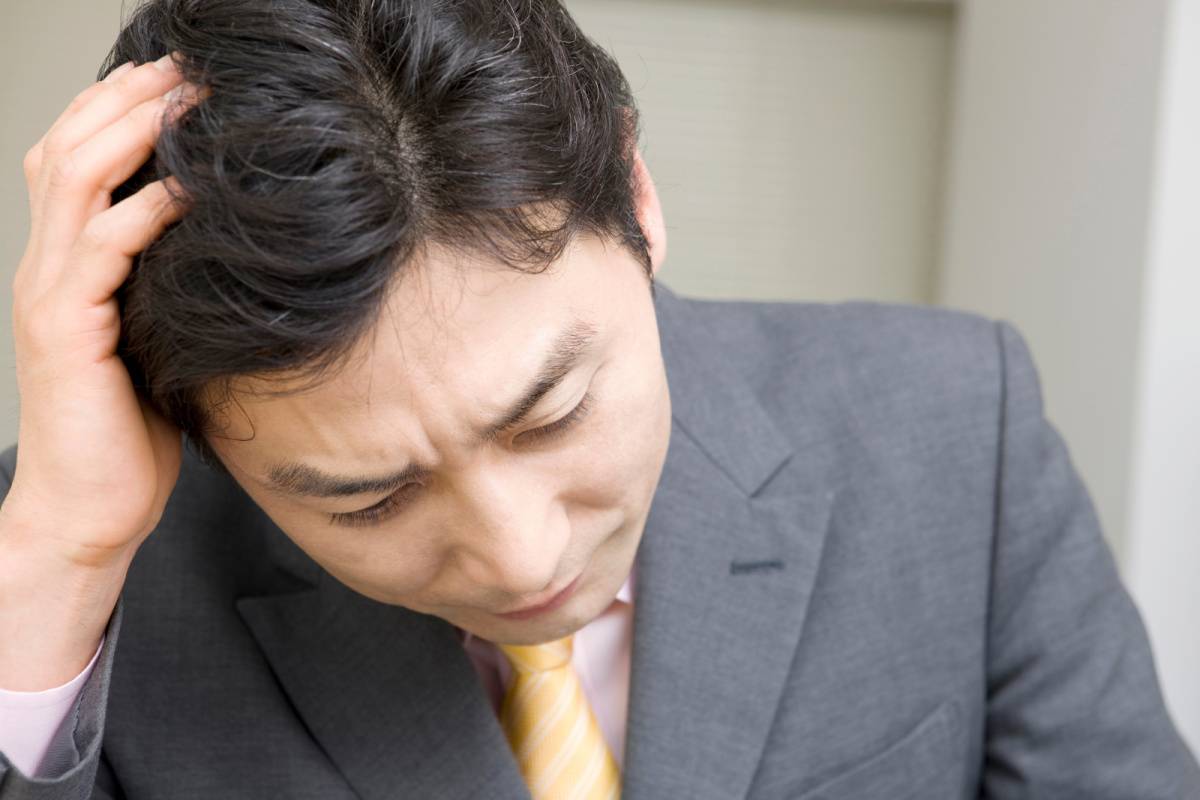 頭を抱えている男性