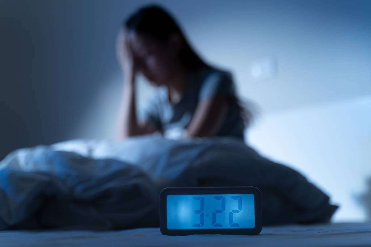 夜ベッドで眠れない女性