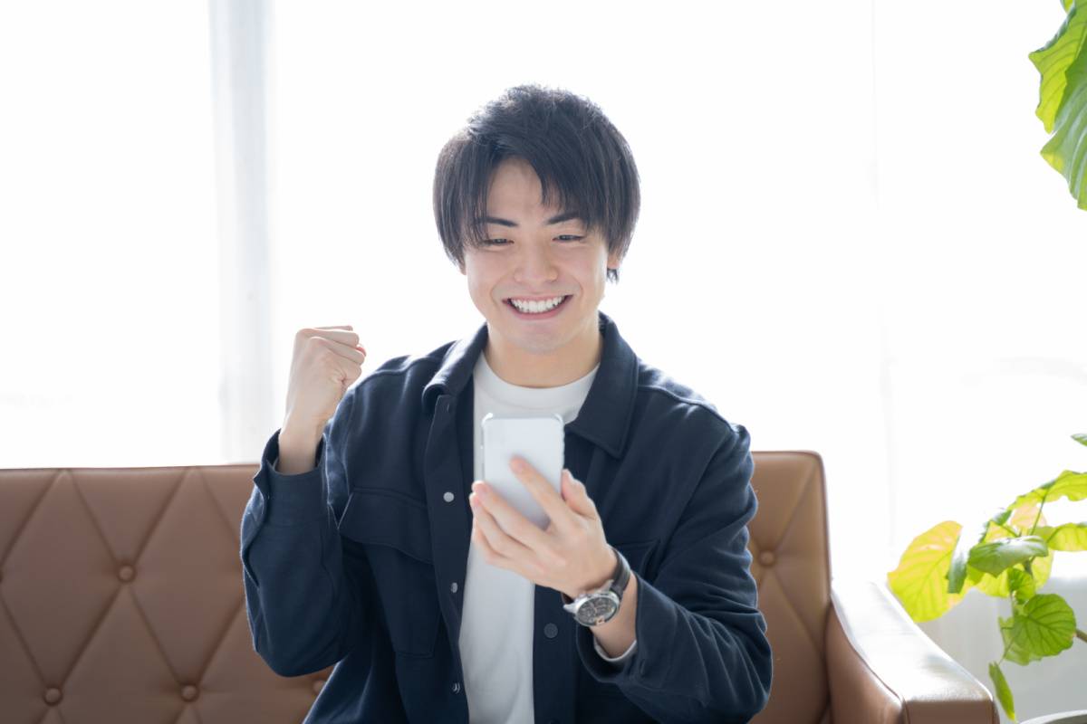 スマートフォンを見て喜んでいる男性