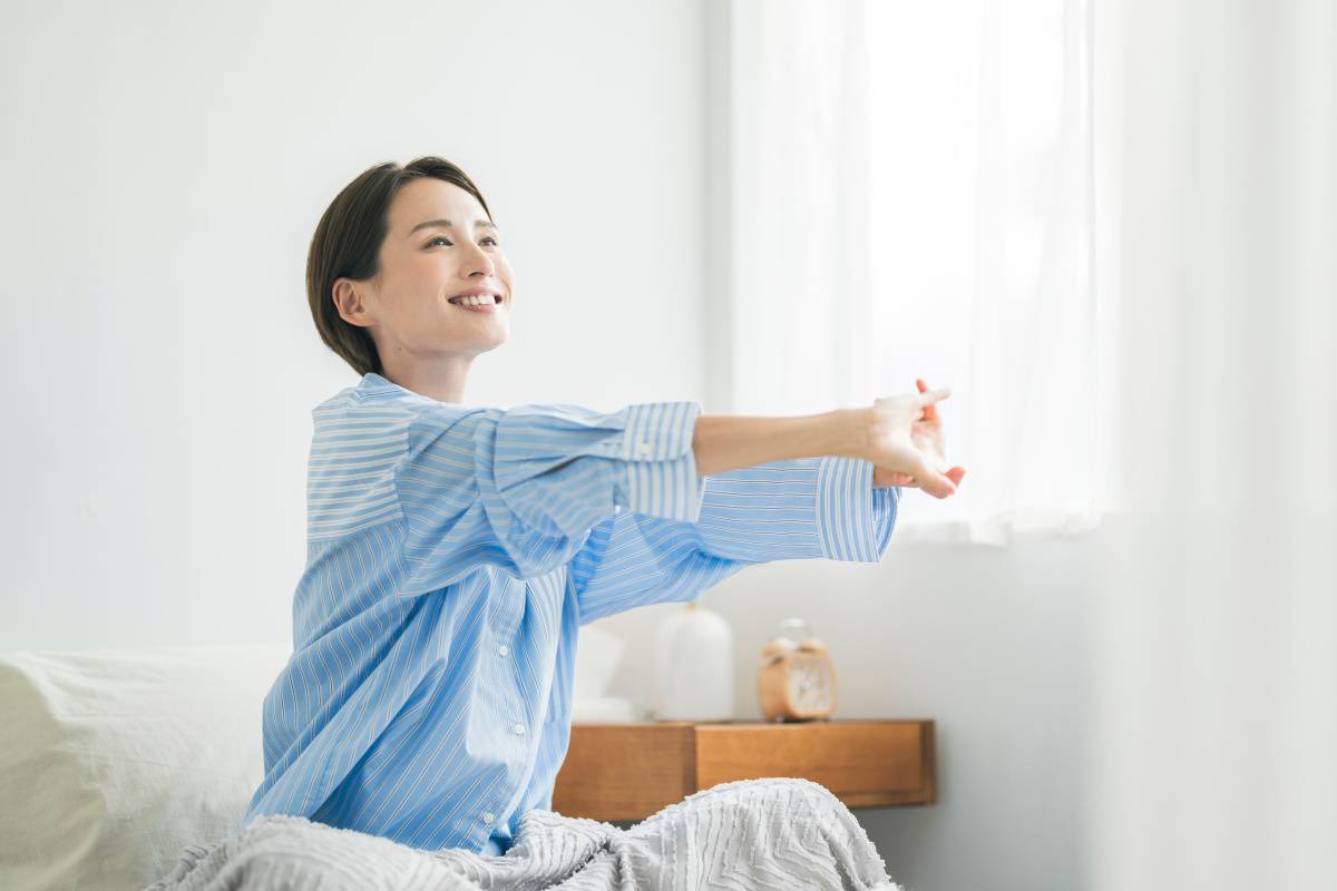 窓辺でストレッチをする女性
