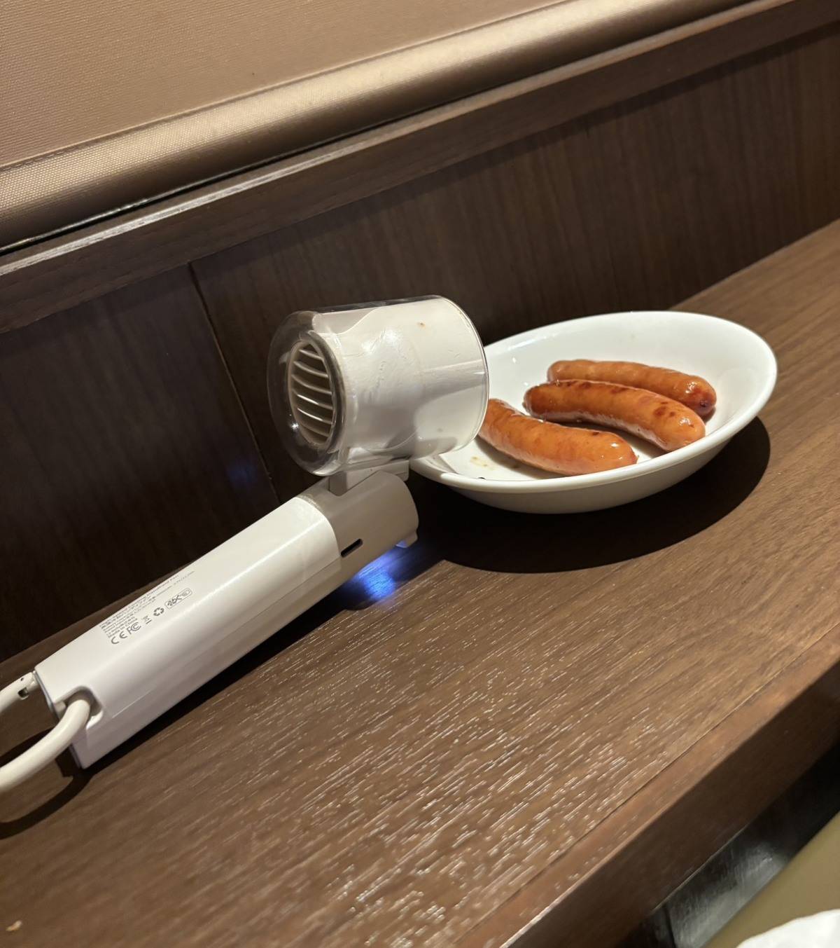 焼肉をハンディファンで冷ましているところ