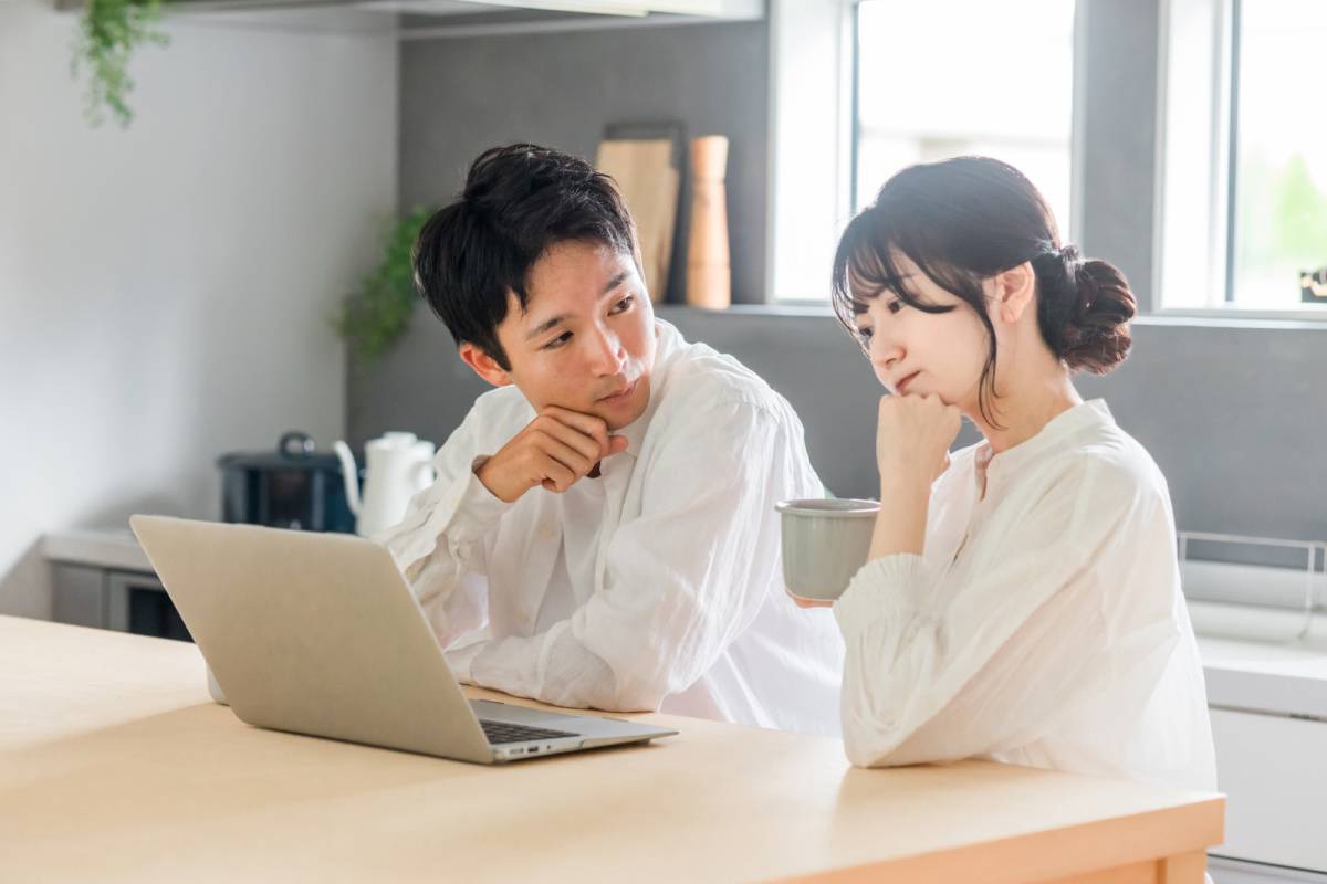 パソコンを見ながら相談している夫婦