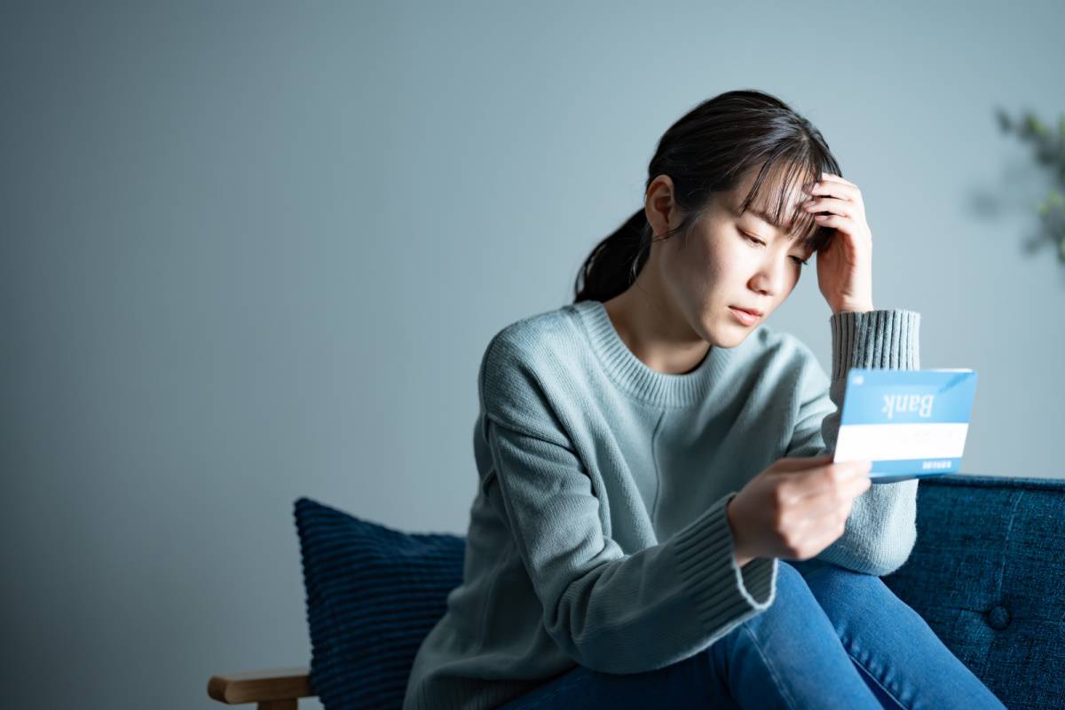 通帳を見て落ち込んでいる女性
