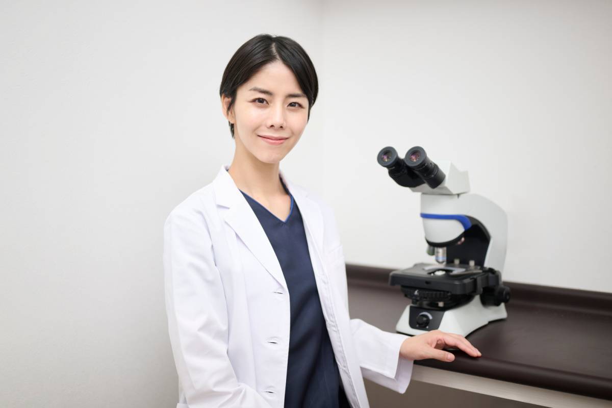 顕微鏡と白衣姿の女性