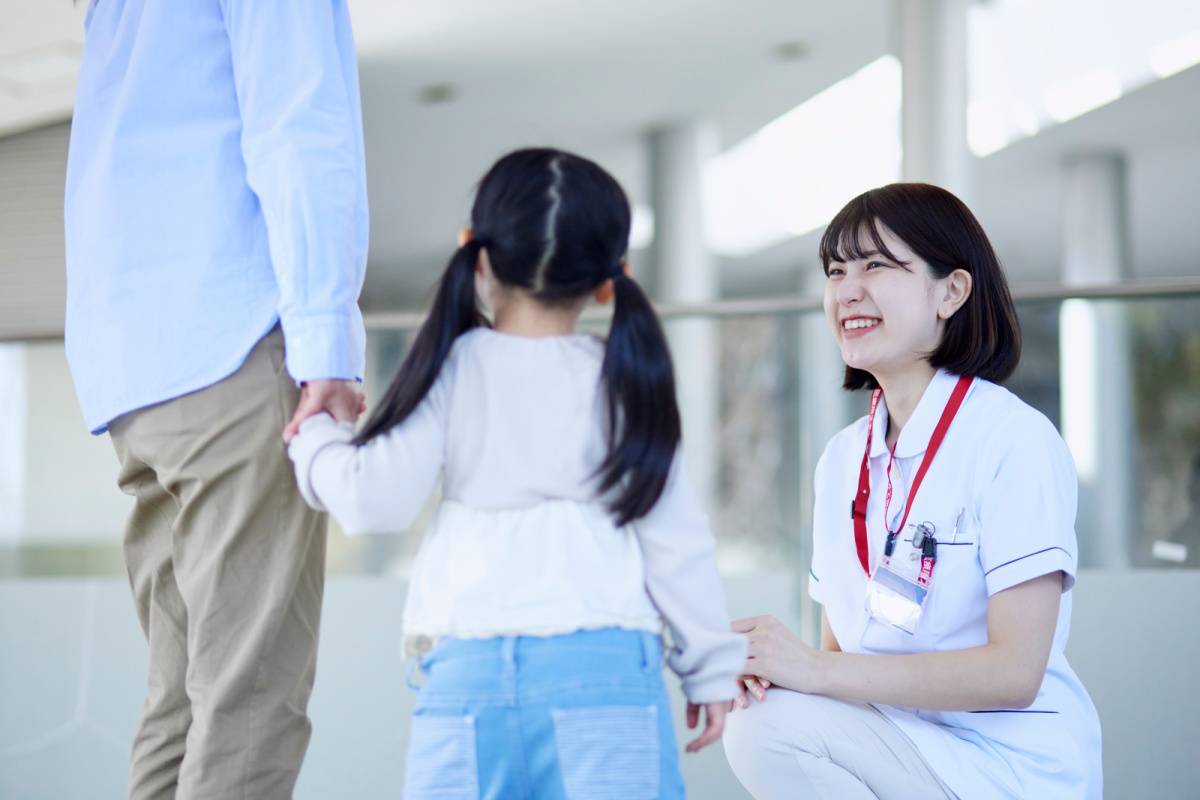 子どもと話している看護師の女性