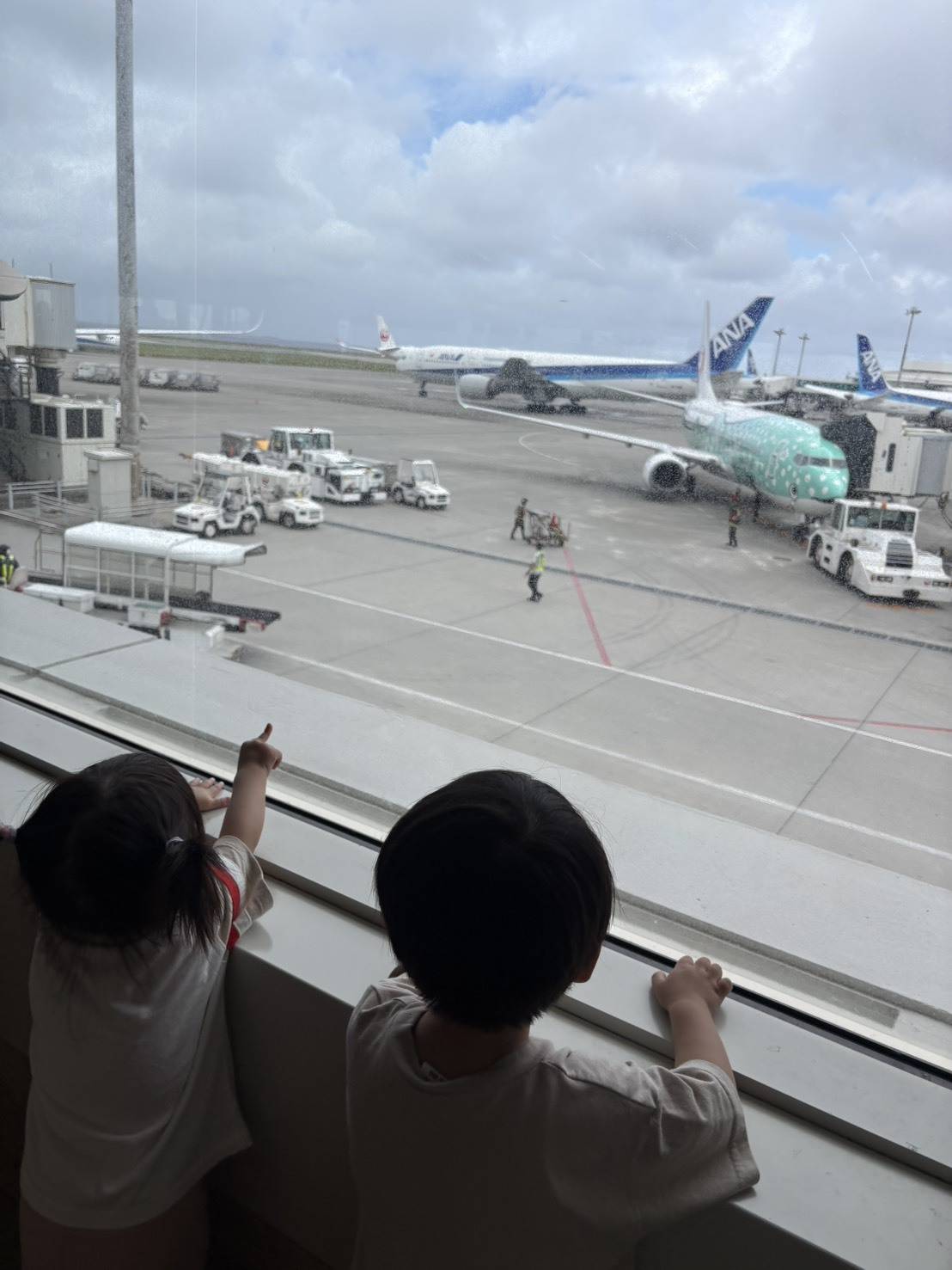 空港で飛行機を見ている子どもたち