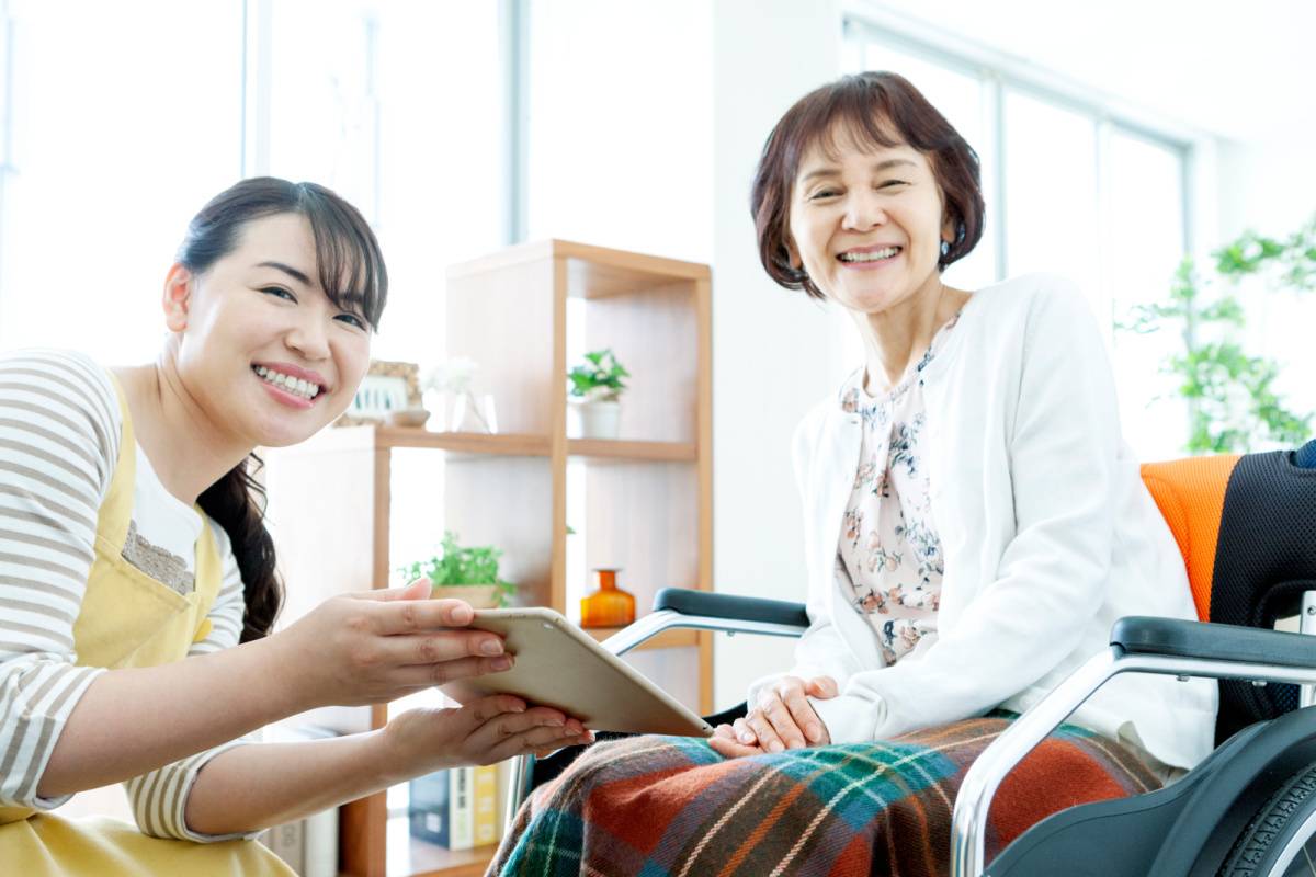 車いすの女性のお世話をしている女性