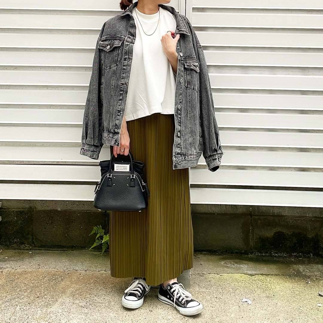 デニムジャケットを肩掛けする