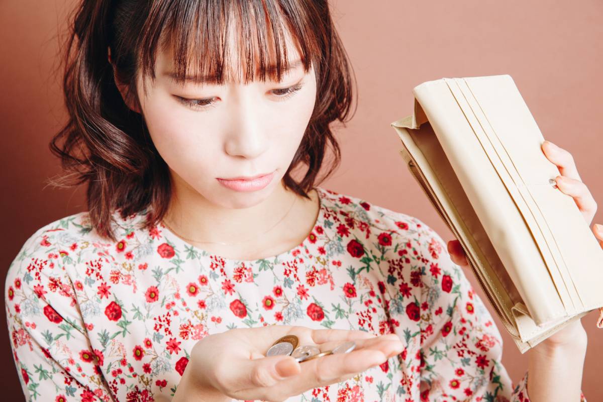 財布の小銭を見ている女性